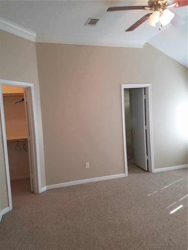 unfurnished bedroom with ornamental molding, visible vents, carpet, and a spacious closet
