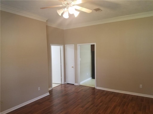 empty room featuring visible vents, a ceiling fan, crown molding, and dark wood-style floors
