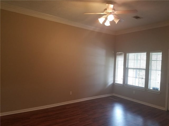 empty room with ceiling fan, visible vents, baseboards, ornamental molding, and dark wood finished floors
