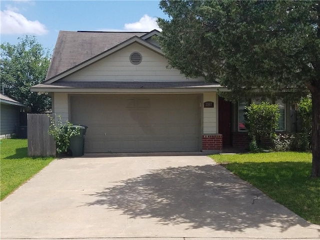 ranch-style house featuring driveway, roof with shingles, a front yard, an attached garage, and brick siding