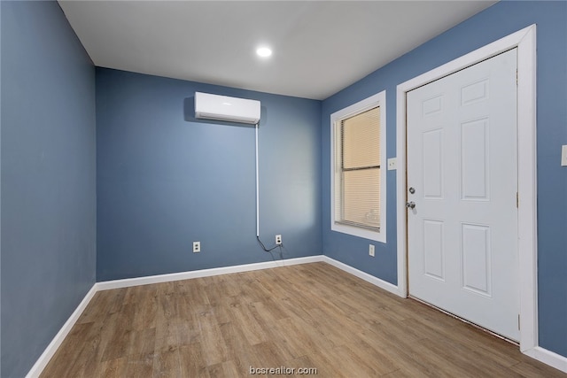 unfurnished room featuring light hardwood / wood-style flooring and a wall mounted AC