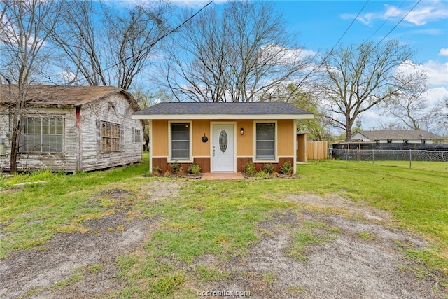 view of front of house with a front yard and an outdoor structure