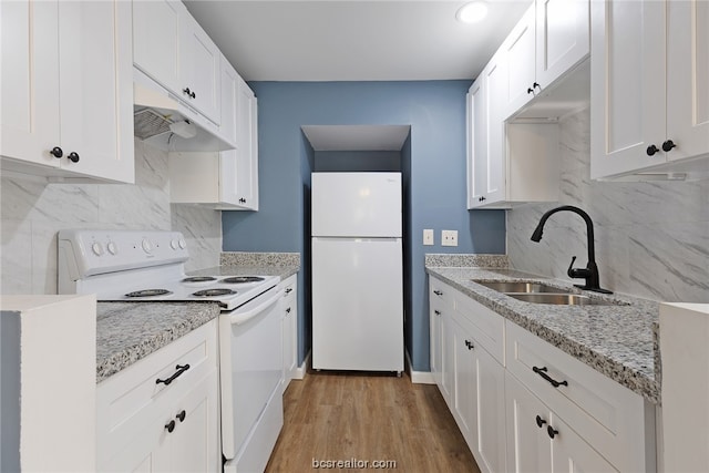 kitchen featuring light stone counters, white appliances, sink, light hardwood / wood-style floors, and white cabinetry