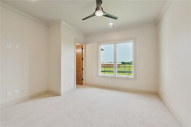 carpeted spare room with ceiling fan and crown molding