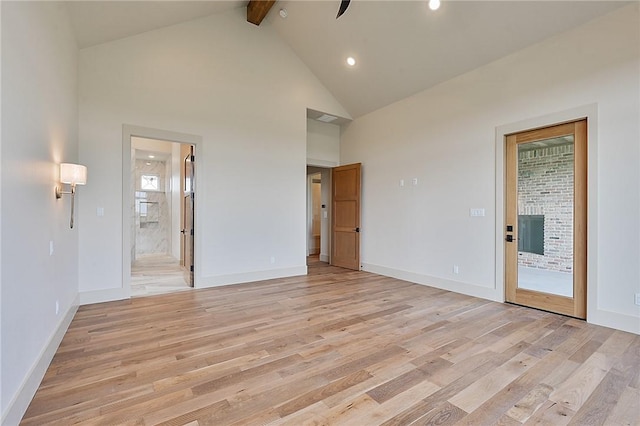 unfurnished room with beam ceiling, light wood-type flooring, and high vaulted ceiling