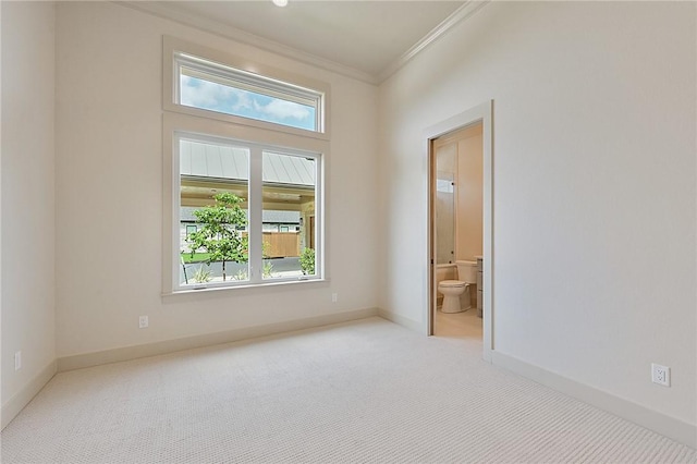 empty room featuring light carpet, plenty of natural light, and crown molding