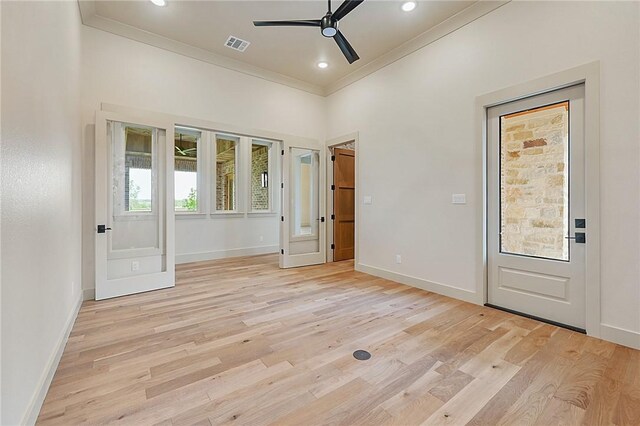 empty room with ceiling fan, light hardwood / wood-style floors, ornamental molding, and french doors