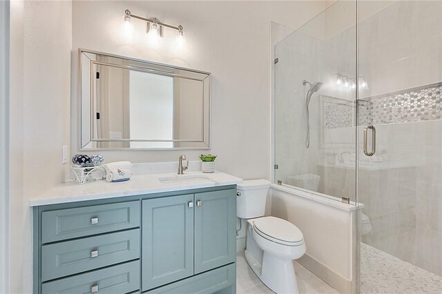 bathroom featuring tile patterned floors, vanity, toilet, and a shower with door