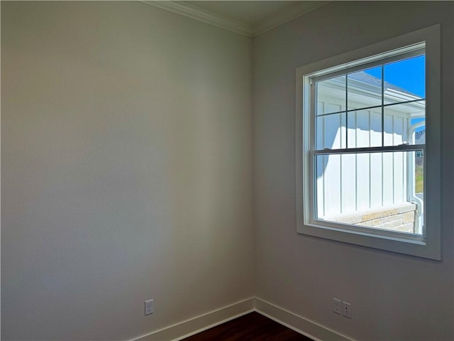 spare room featuring crown molding and dark wood-type flooring