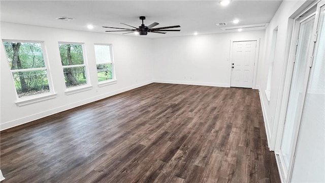 empty room featuring ceiling fan, plenty of natural light, and dark hardwood / wood-style floors