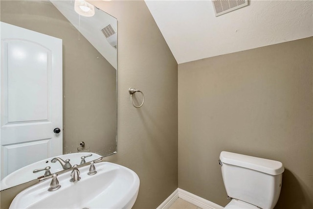 bathroom featuring visible vents, toilet, baseboards, and a sink