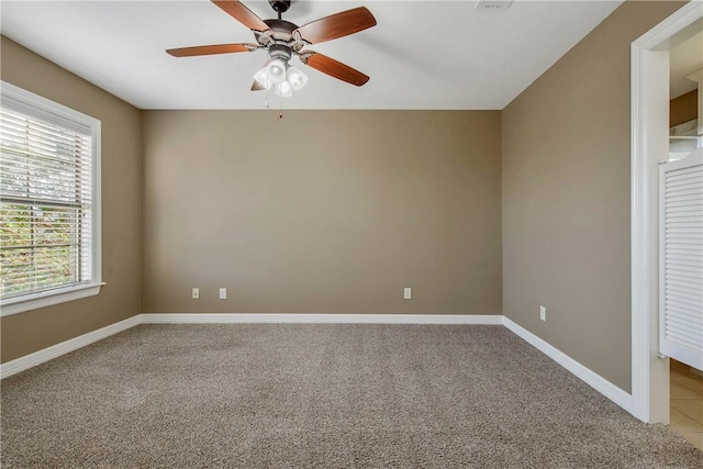 empty room with baseboards, light colored carpet, and a ceiling fan