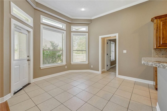 interior space with light tile patterned floors, baseboards, and ornamental molding