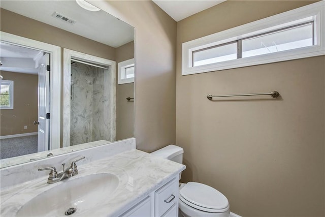 bathroom featuring visible vents, toilet, vanity, and baseboards