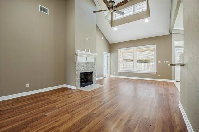 unfurnished living room featuring visible vents, wood finished floors, baseboards, and ceiling fan