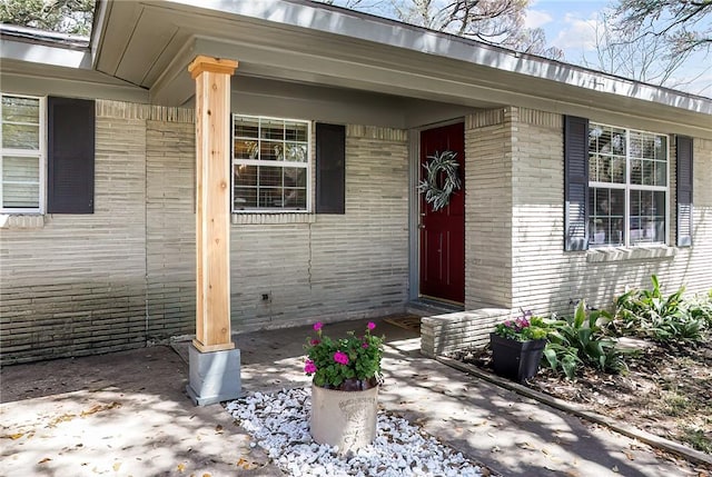 view of exterior entry with brick siding