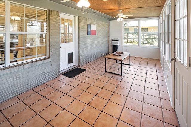 unfurnished sunroom featuring ceiling fan