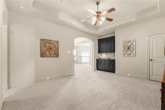 11376 Majestic Dr, Montgomery, TX 77356 - carpeted spare room featuring arched walkways, a tray ceiling, a ceiling fan, and baseboards