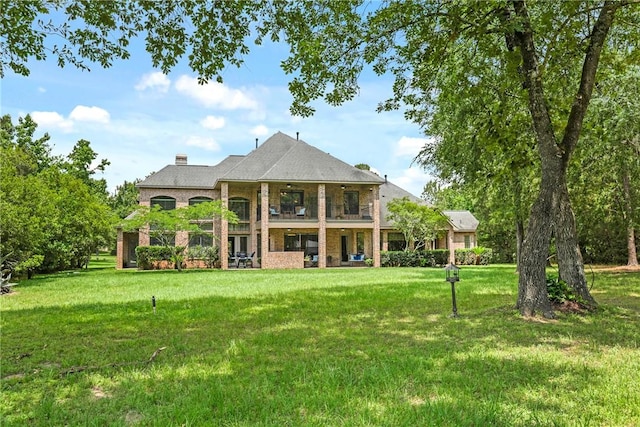 11376 Majestic Dr, Montgomery, TX 77356 - rear view of house with a balcony, a yard, and brick siding
