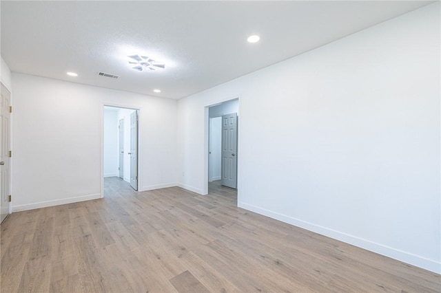 empty room with light hardwood / wood-style floors and a textured ceiling