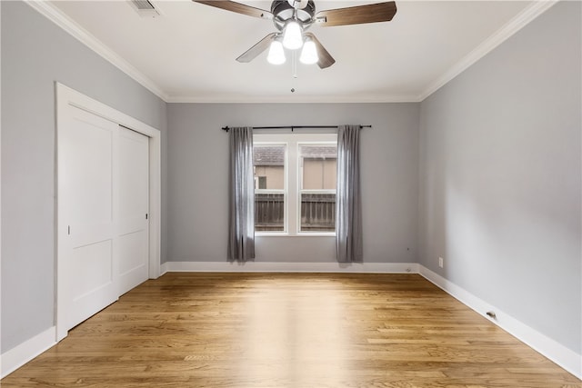 empty room with visible vents, light wood-style flooring, and ornamental molding