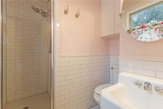 full bath with a shower stall, a wainscoted wall, toilet, tile walls, and a sink