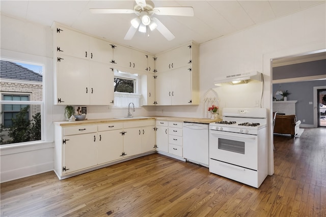 kitchen featuring under cabinet range hood, white appliances, light countertops, and a sink