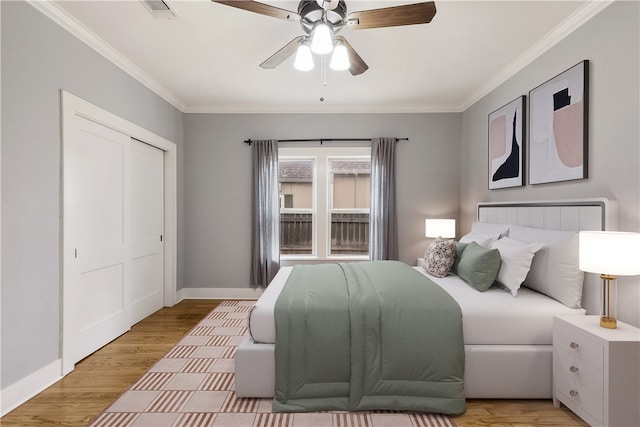 bedroom featuring crown molding, light wood-style floors, visible vents, and baseboards