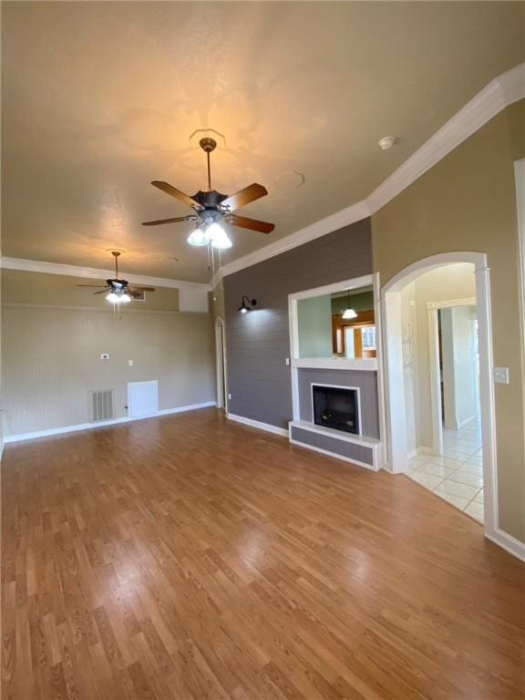 unfurnished living room featuring ceiling fan, light hardwood / wood-style floors, and crown molding