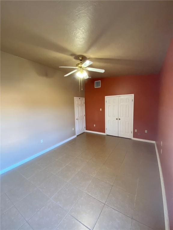 unfurnished bedroom with ceiling fan and a closet