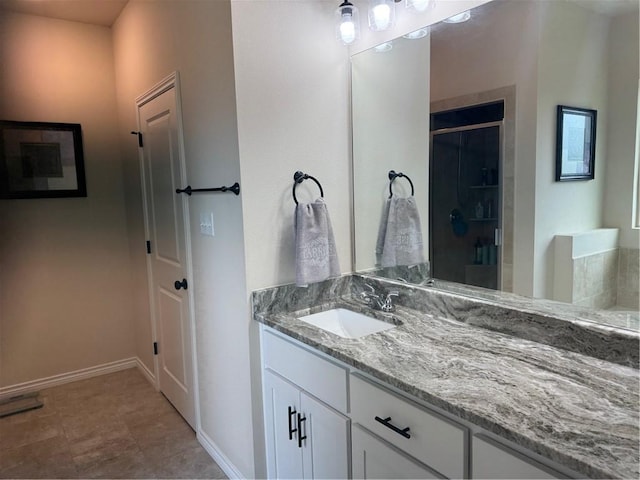bathroom featuring baseboards, vanity, and a shower stall