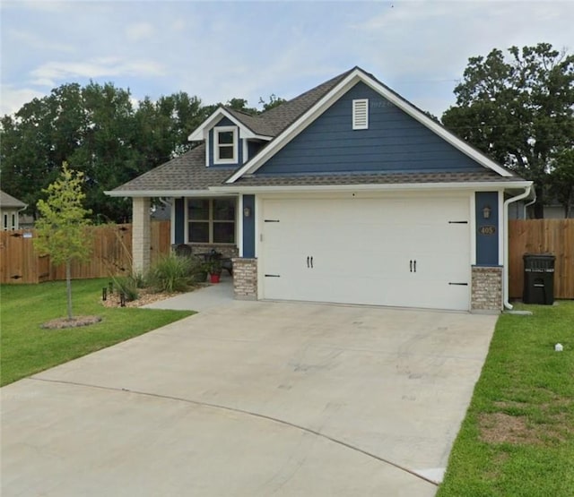 craftsman-style house with fence, driveway, a front lawn, and a garage