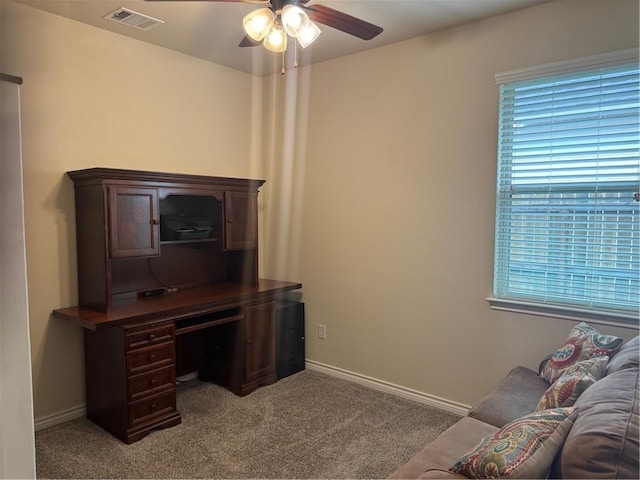 office space with a ceiling fan, baseboards, visible vents, and light carpet