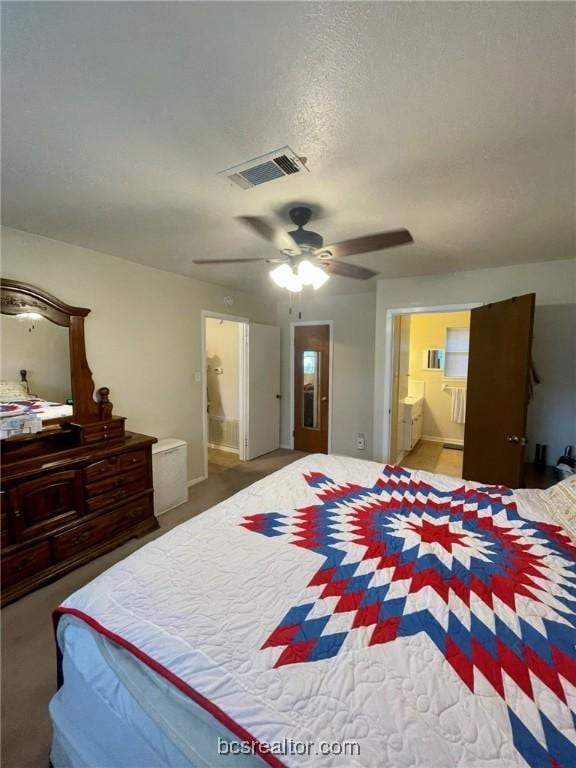 carpeted bedroom featuring a textured ceiling, connected bathroom, and ceiling fan