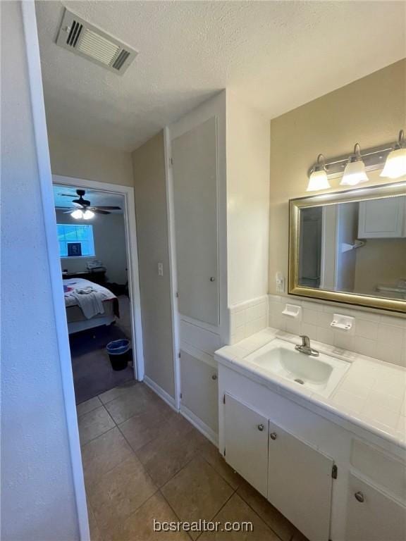 bathroom with vanity, a textured ceiling, tile patterned floors, and ceiling fan