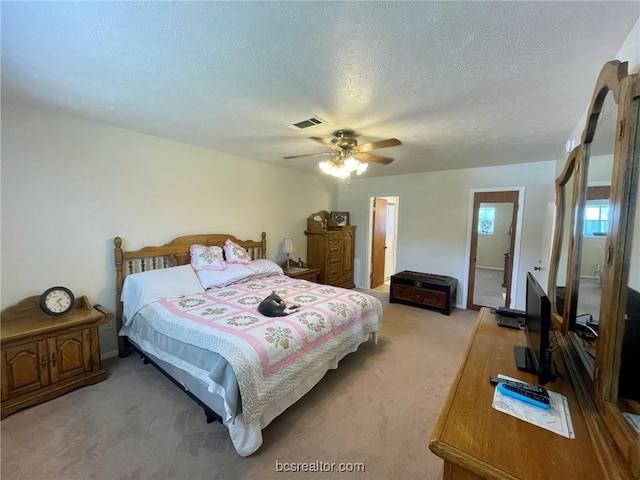 carpeted bedroom with ceiling fan and a textured ceiling