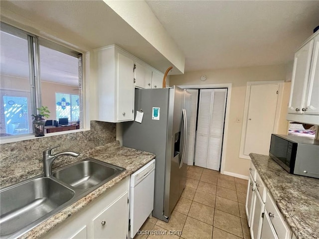 kitchen with light tile patterned floors, stainless steel appliances, white cabinetry, and sink