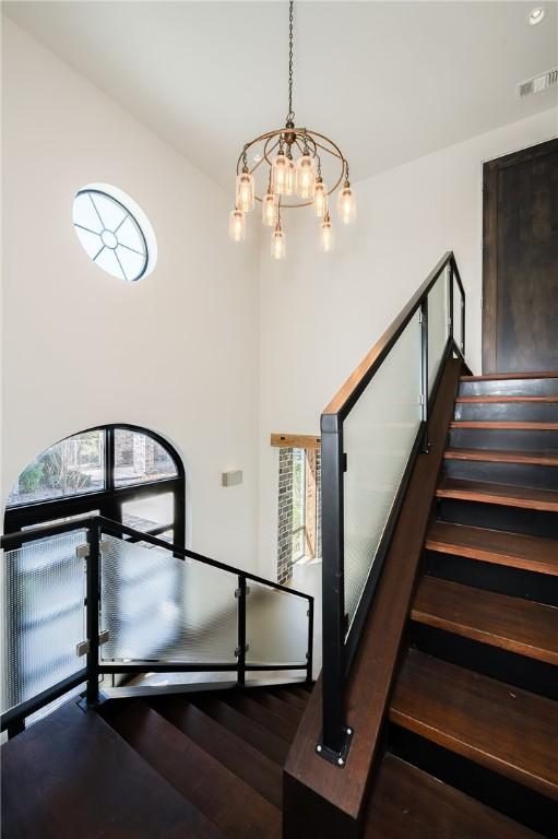 stairs with a notable chandelier and visible vents