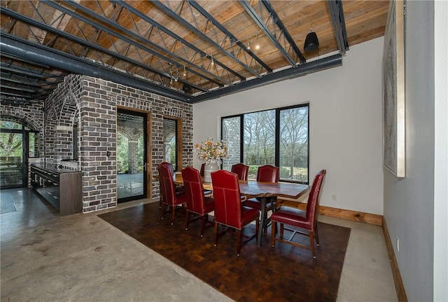 dining area featuring a high ceiling, plenty of natural light, wood ceiling, and baseboards