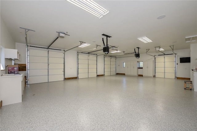 garage with visible vents, a garage door opener, and separate washer and dryer