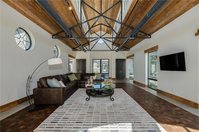 living area featuring a wealth of natural light, high vaulted ceiling, and baseboards