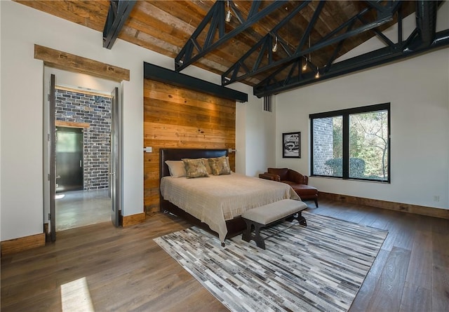 bedroom featuring beamed ceiling, high vaulted ceiling, hardwood / wood-style floors, wooden ceiling, and baseboards