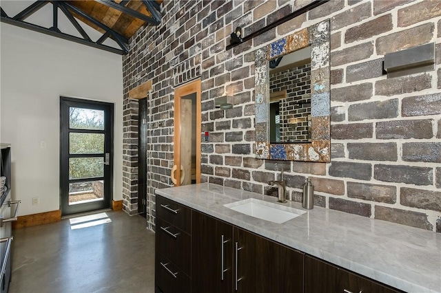 kitchen with lofted ceiling, finished concrete floors, a sink, light countertops, and modern cabinets