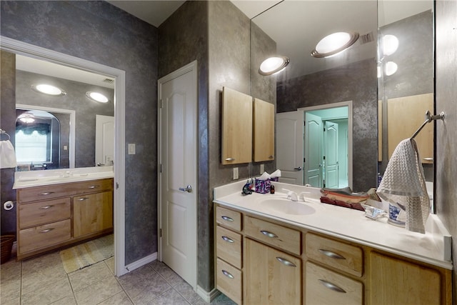 bathroom featuring vanity, baseboards, and tile patterned floors