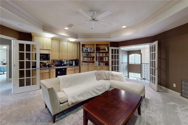 living room with crown molding, a ceiling fan, a raised ceiling, and light carpet