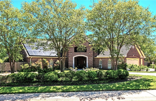 view of front of house featuring fence, concrete driveway, a garage, and brick siding