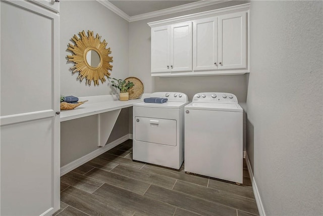 clothes washing area featuring washing machine and clothes dryer, crown molding, dark wood-type flooring, and cabinets