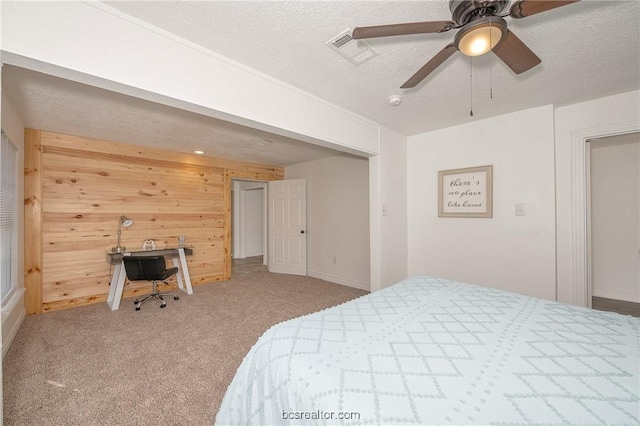 carpeted bedroom featuring a textured ceiling, ceiling fan, and wood walls