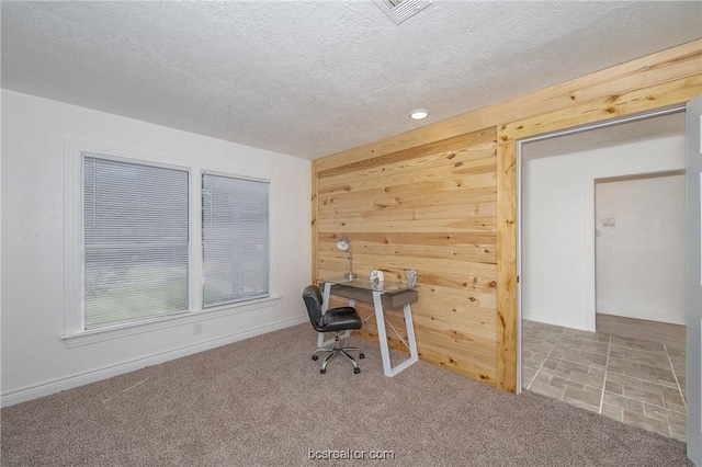 office featuring wood walls, carpet floors, and a textured ceiling