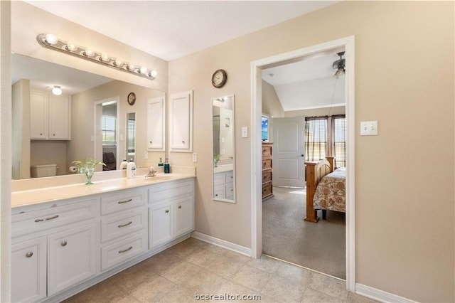 bathroom featuring tile patterned floors, vanity, lofted ceiling, and toilet